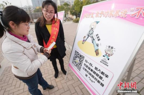 資料圖：今年3月8日，安徽合肥新華社區(qū)志愿者夏一瓊(右)向市民普及反家暴相關(guān)法律知識(shí)。鐘欣 攝